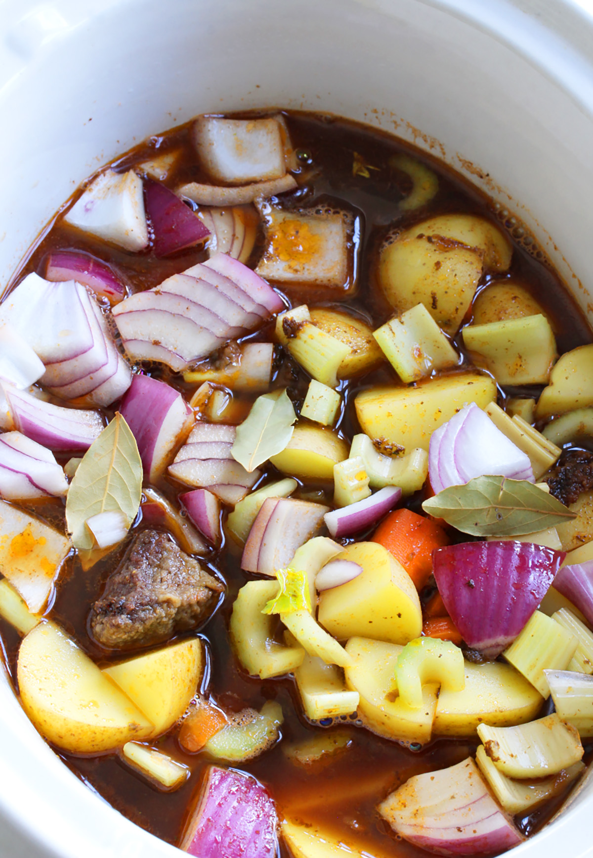 Adding ingredients to a slow cooker to make low sodium beef stew