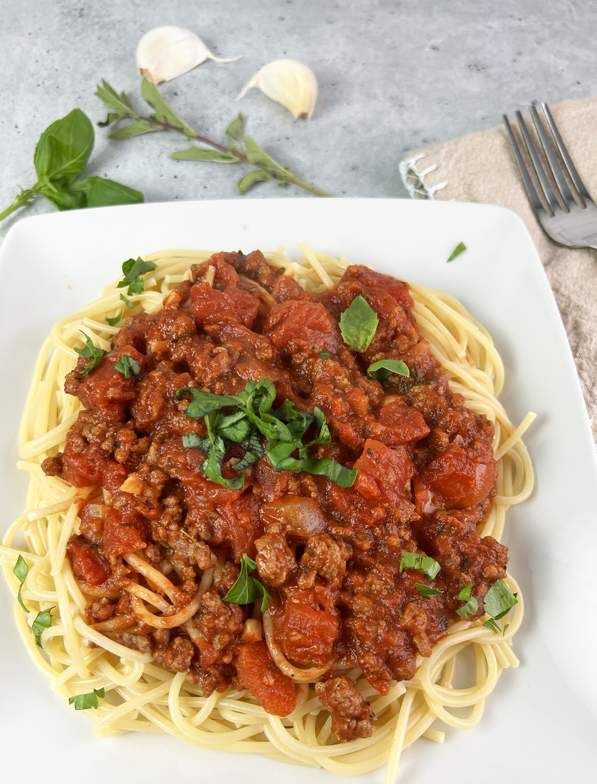 A plate of spaghetti that is topped with low sodium spaghetti meat sauce