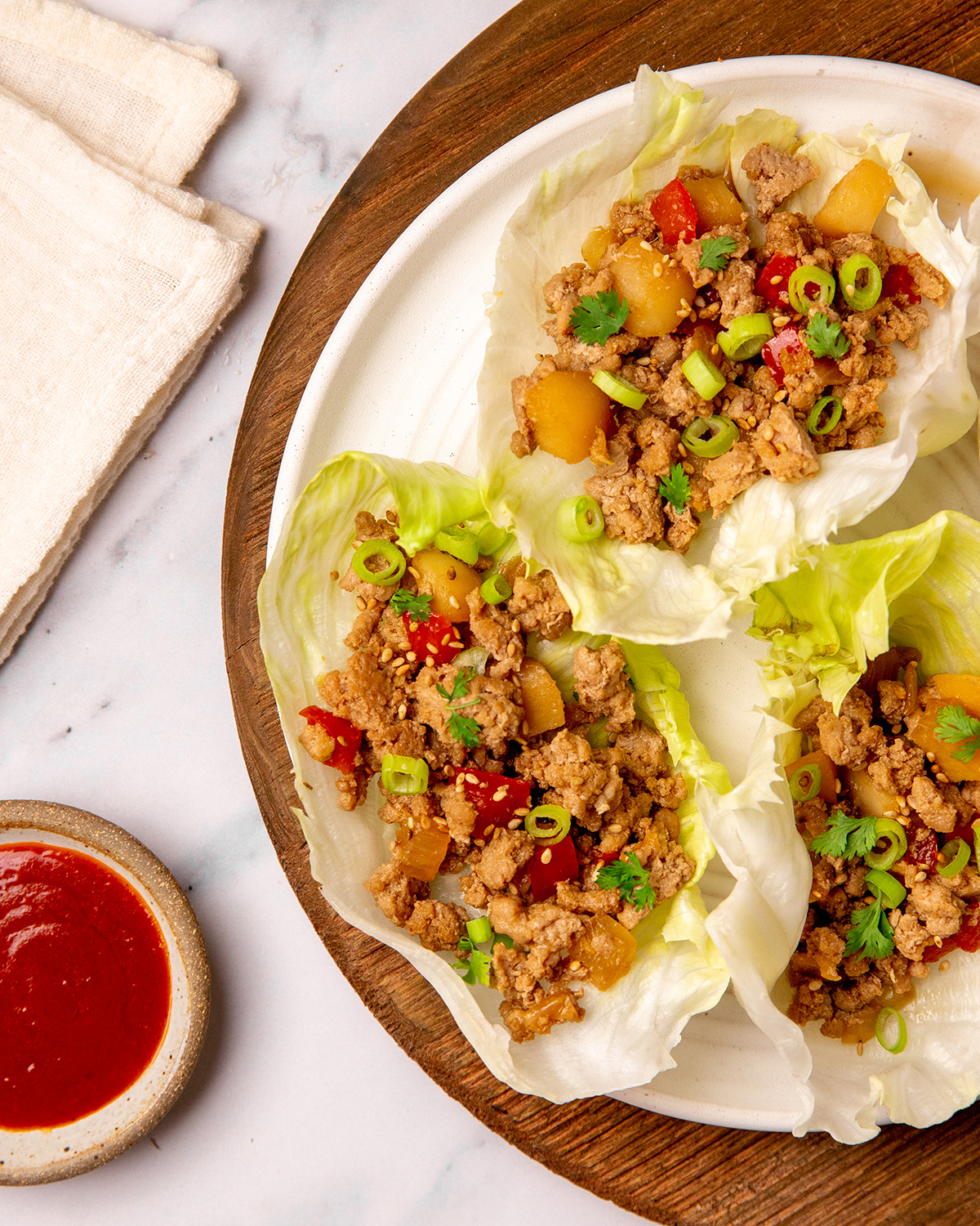 Low sodium Asian turkey lettuce wraps served on a plate with sauce on the side.