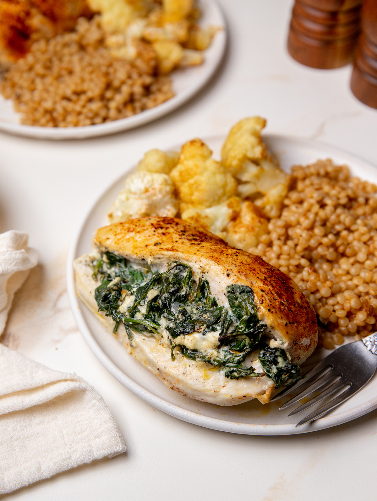 A serving of spinach stuffed chicken on a white plate.
