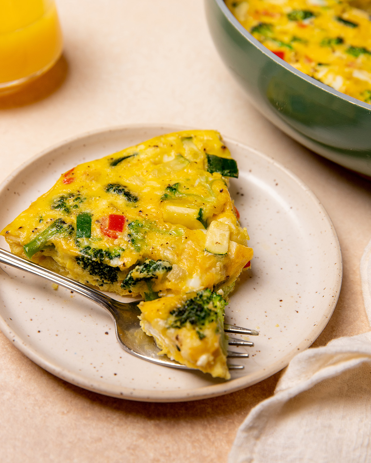 A slice of low sodium frittata on a white plate with a fork.