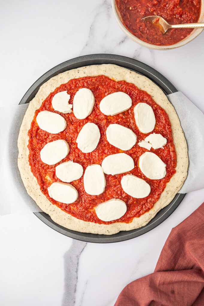 Fresh mozzarella on a pizza before getting baked in the oven.