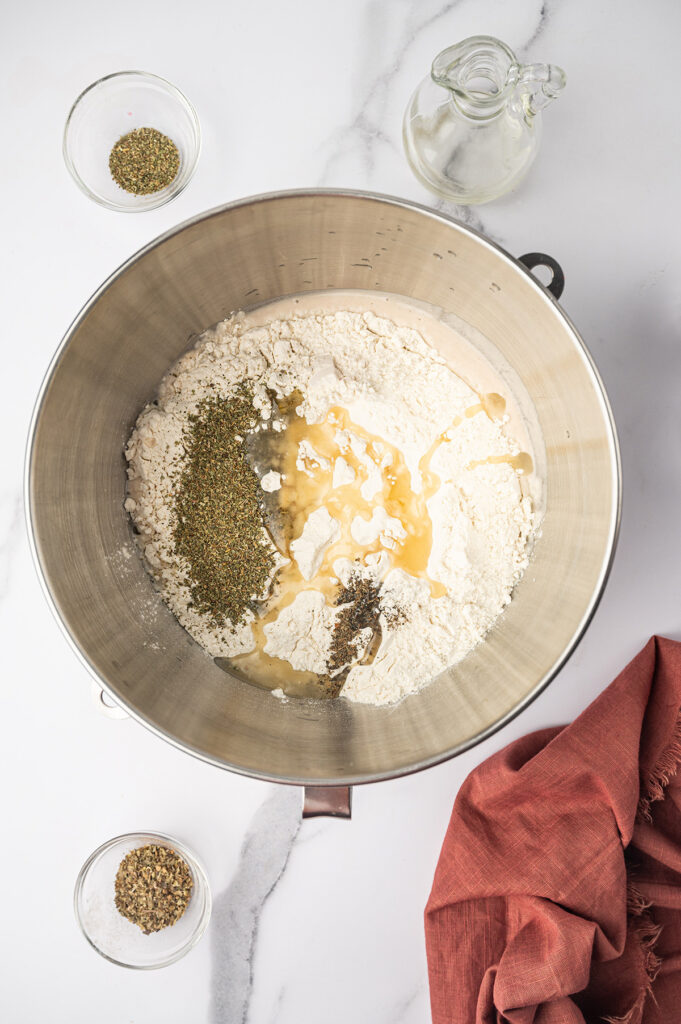 Mixing ingredients in a bowl for pizza dough.