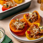 Three low-sodium stuffed peppers in a white bowl.