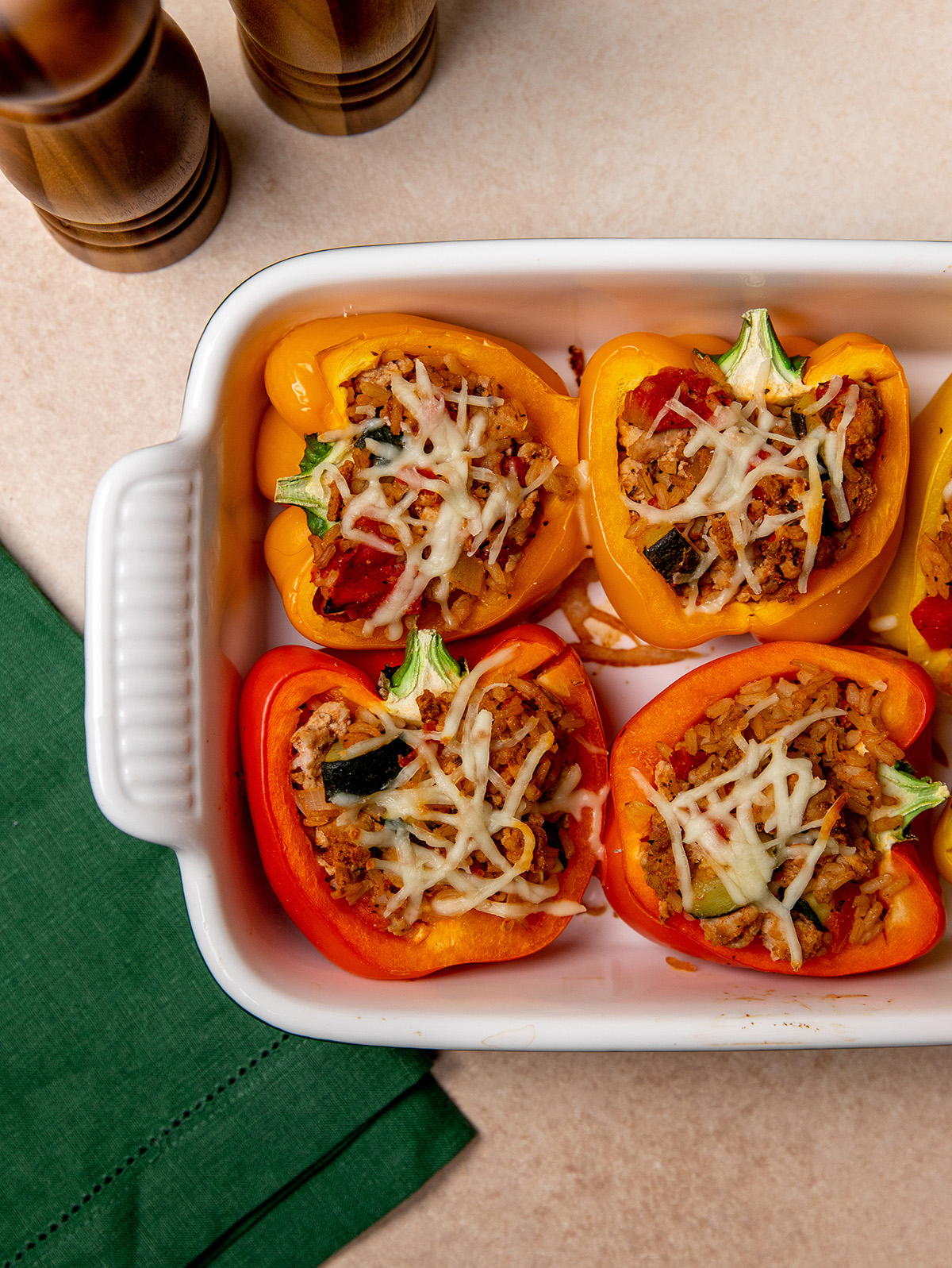 Low-sodium stuffed peppers in a baking dish with cheese on top.