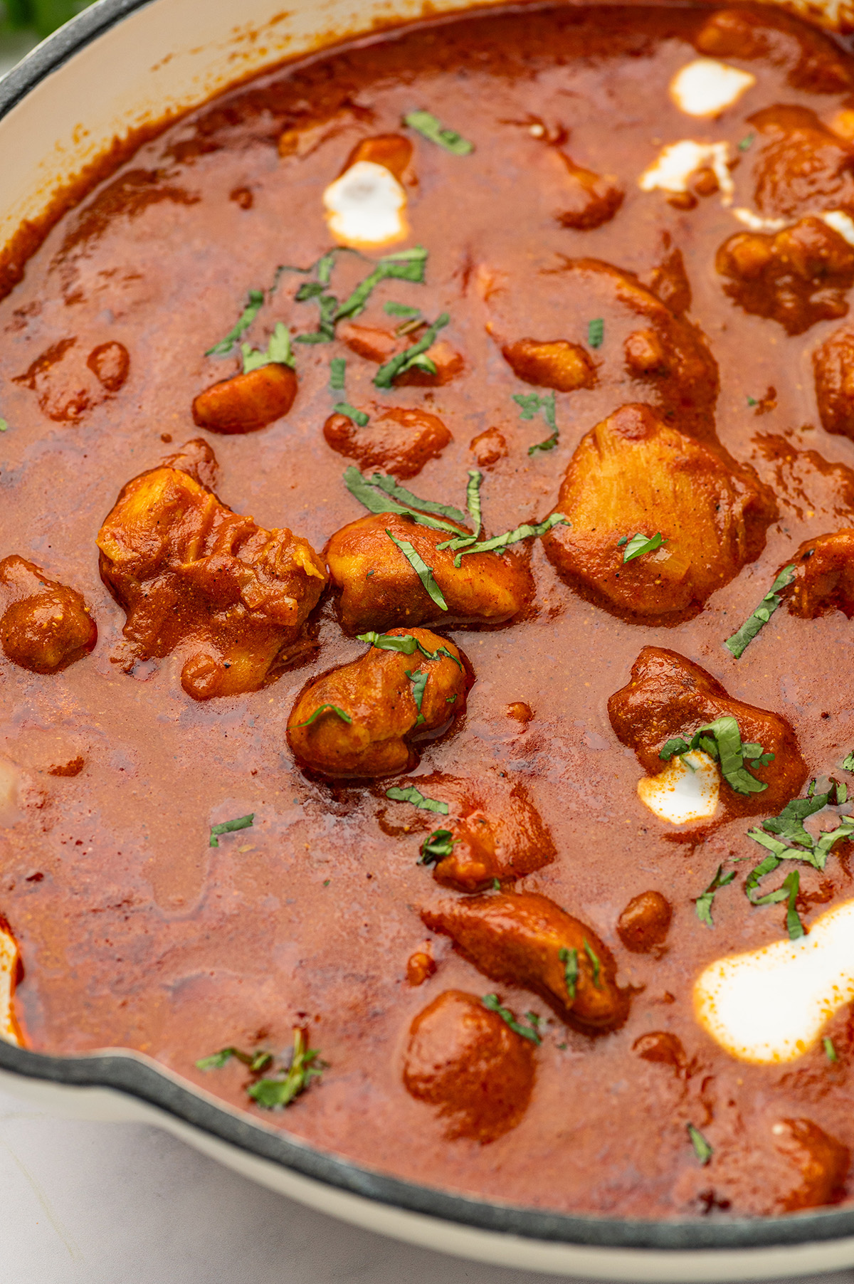 A skillet of low sodium butter chicken on the stove, with the creamy sauce and tender chicken pieces simmering together.