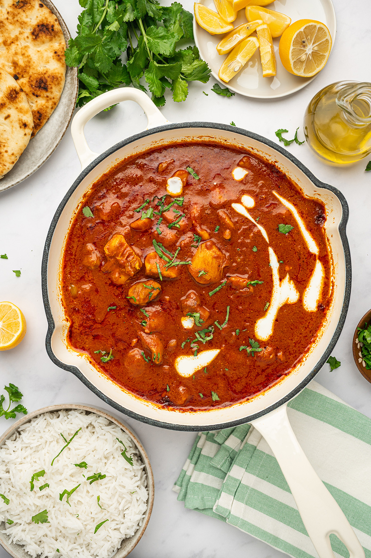 Low sodium butter chicken in a skillet, with the creamy sauce bubbling and tender chicken pieces coated in warm spices.