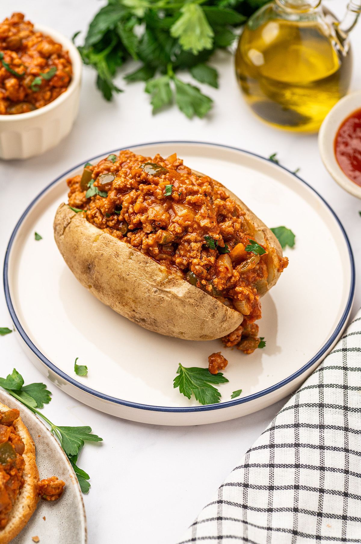 A comforting baked potato filled with low sodium sloppy joes, topped with a simple garnish of fresh parsley.