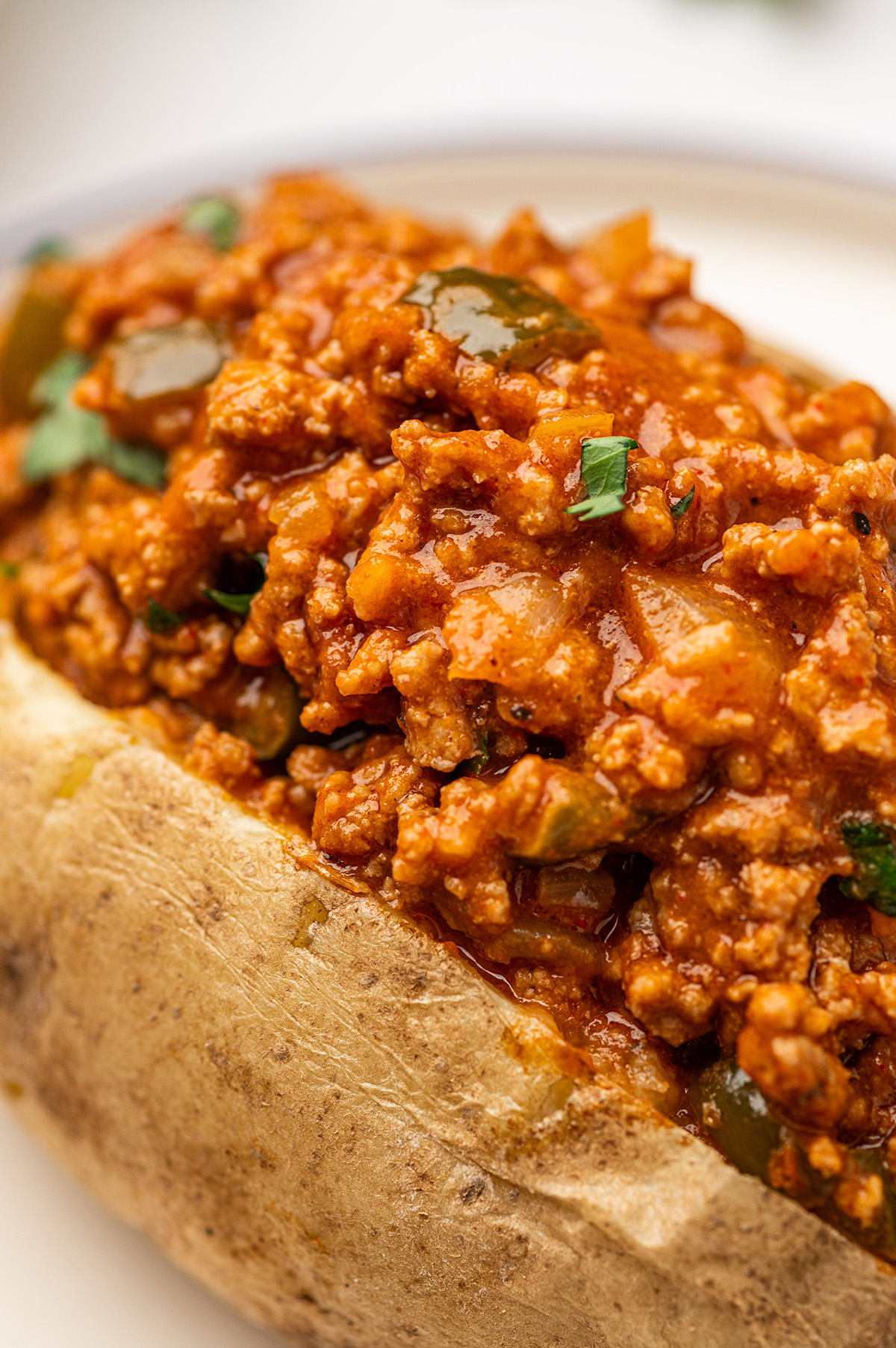 A classic baked potato loaded with low sodium sloppy joes, finished with a sprinkle of parsley for added color and flavor.