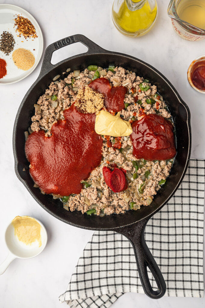 A skillet filled with savory low sodium sloppy joes mixture, featuring ground meat, and tomato sauce.