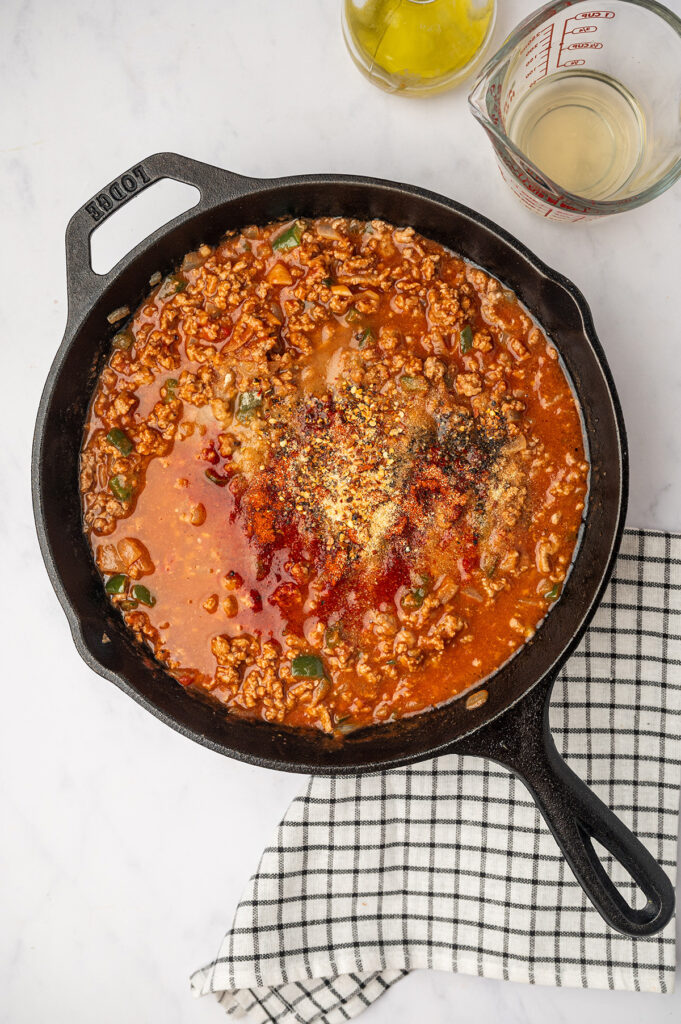 A skillet filled with savory low sodium sloppy joes mixture, featuring ground meat, tomato sauce, and a homemade seasoning blend.