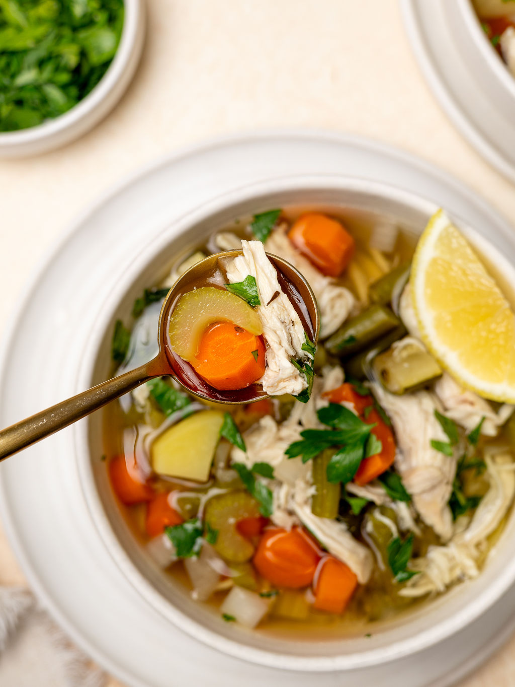 Close up of low sodium chicken and vegetable soup with a spoon.